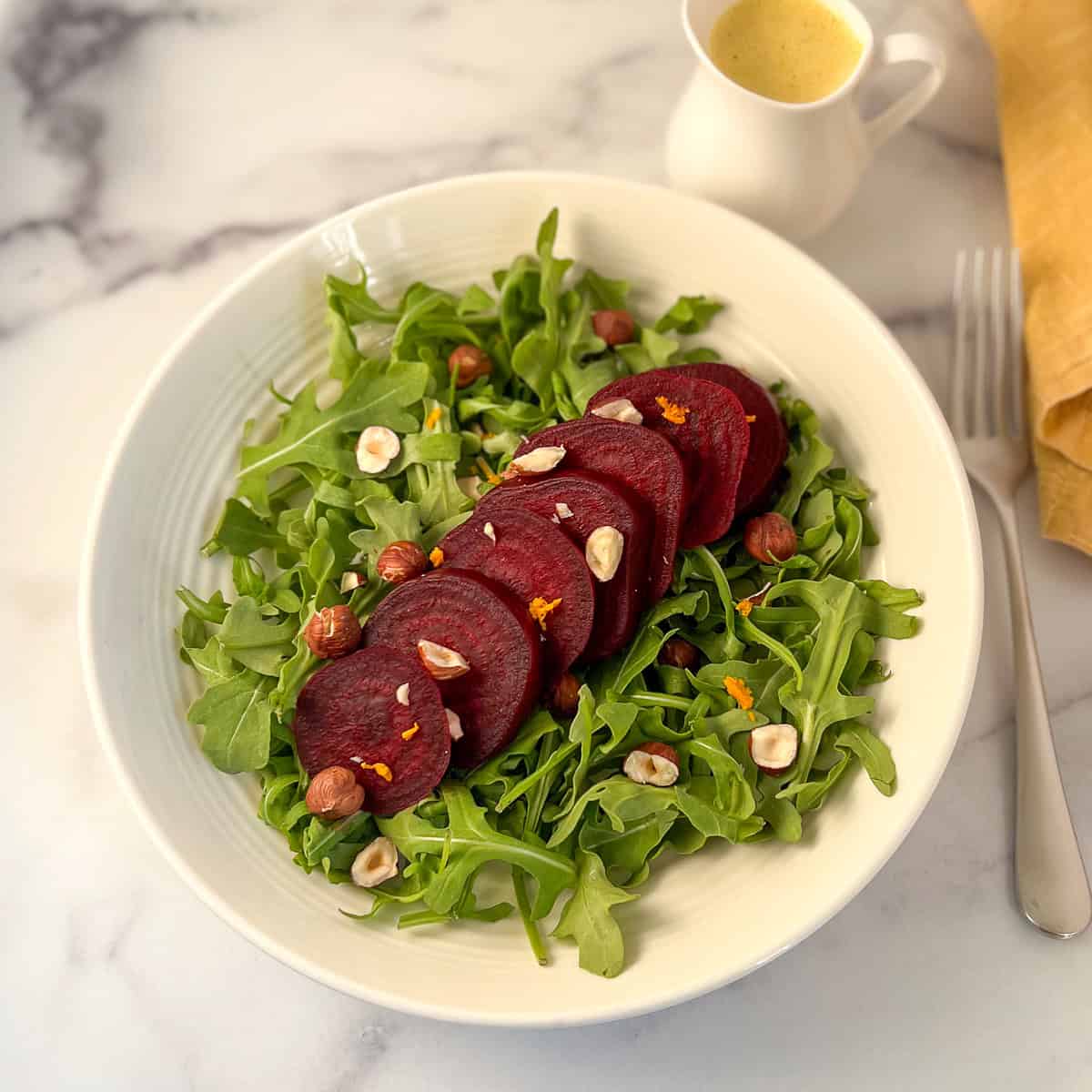 Beet arugula salad assembled in a bowl.
