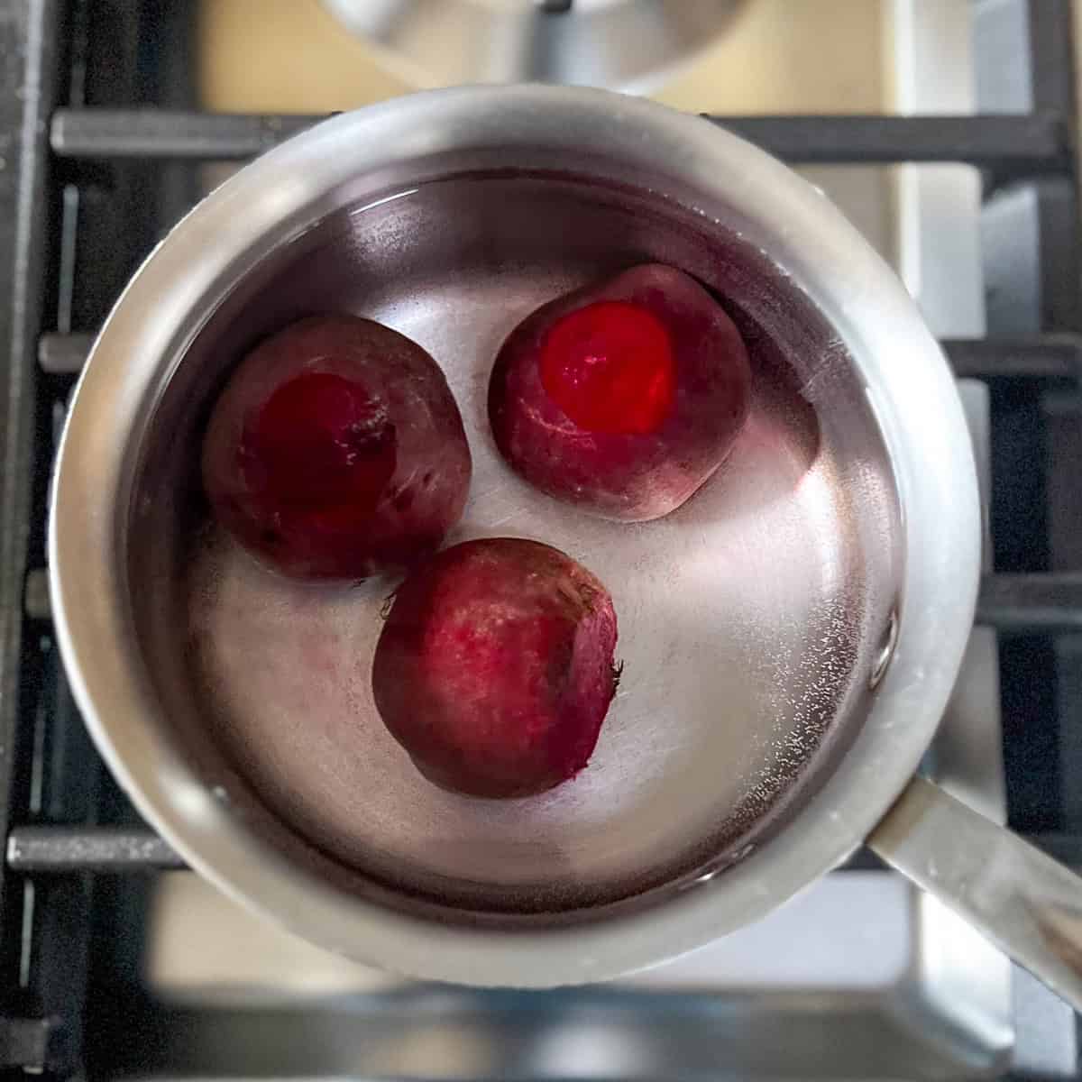 Beets in a pot of water being cooked on the stovetop.