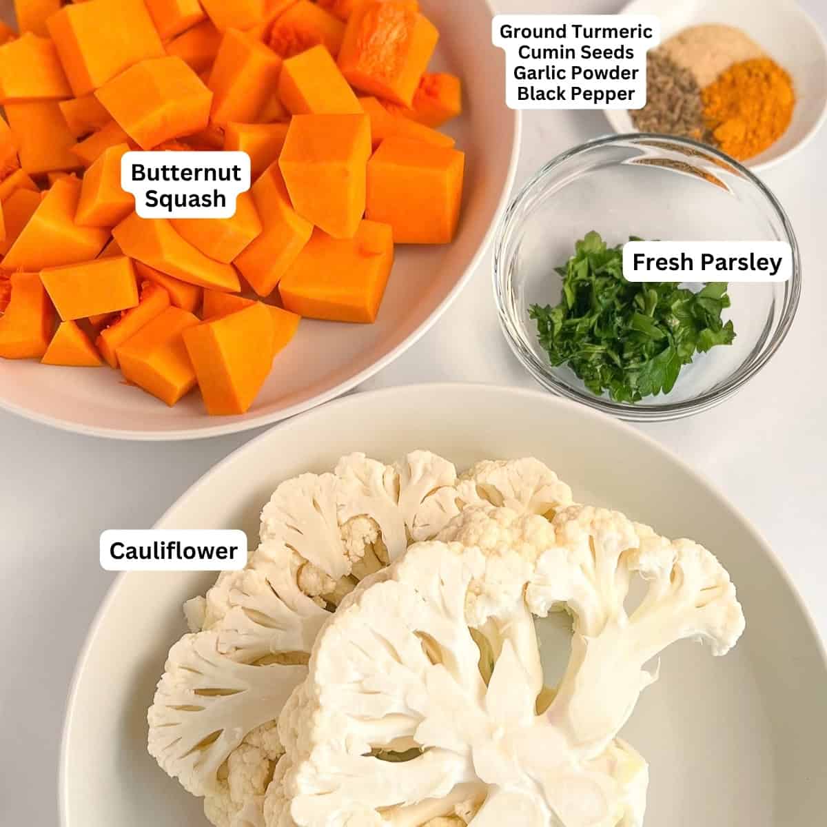 Key ingredients for the recipe: butternut squash chunks, cauliflower, spices, fresh chopped parsley.