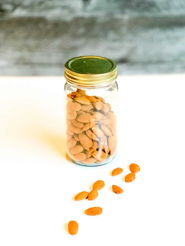 A mason jar with raw almonds.