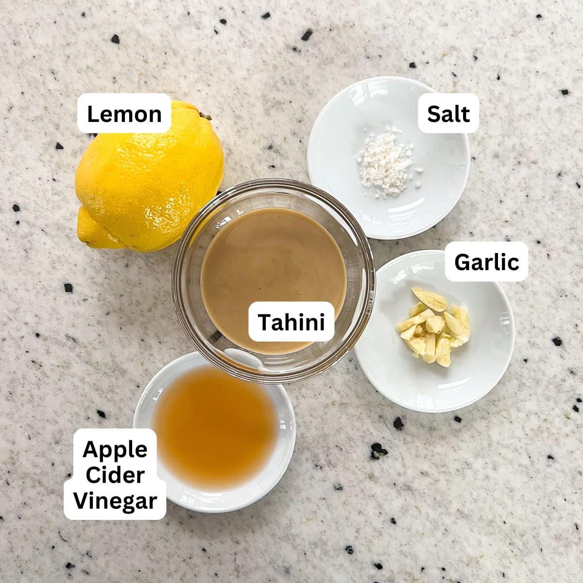 Ingredients for the lemon tahini dressing: tahini, lemon, garlic, and apple cider vinegar.
