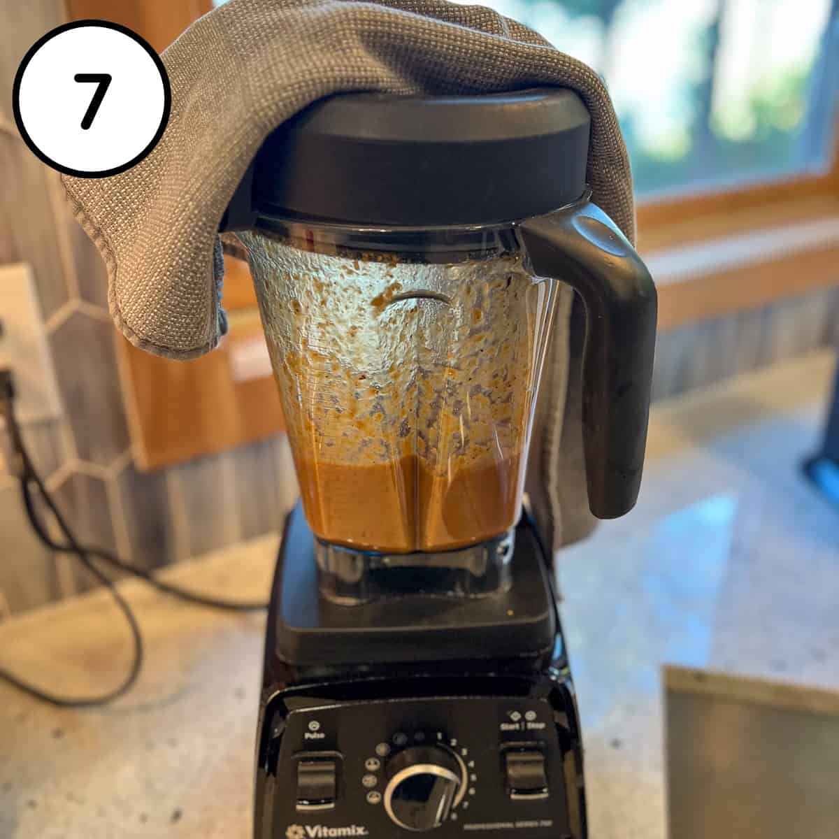Some of the lentil soup mixture being blended in a blender with a vented lid.