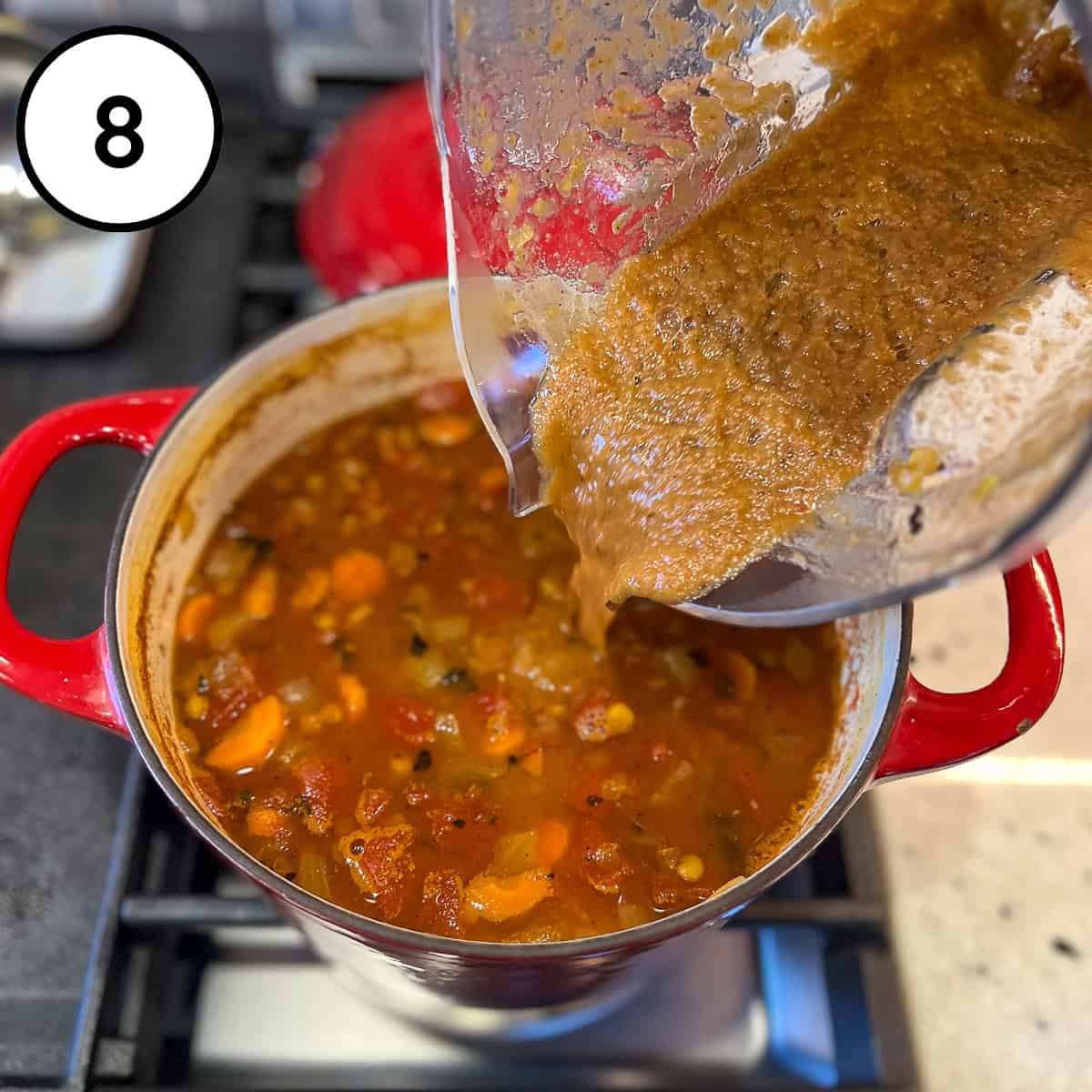 Blended lentil soup being poured back into the pot to make it creamier.