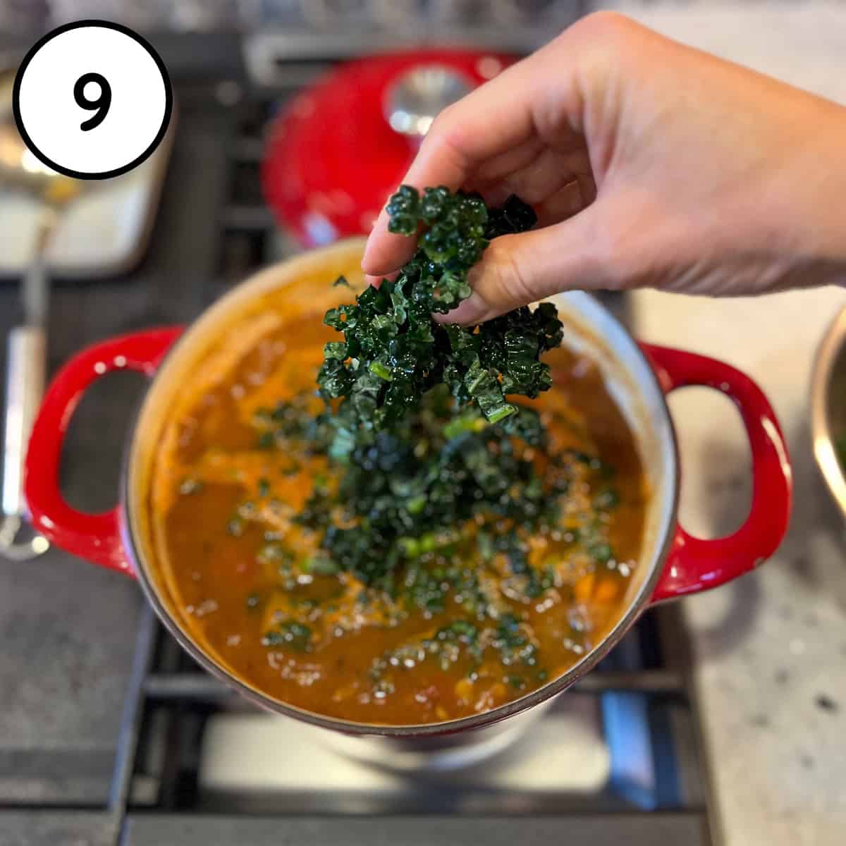 Chopped kale being added to the pot.