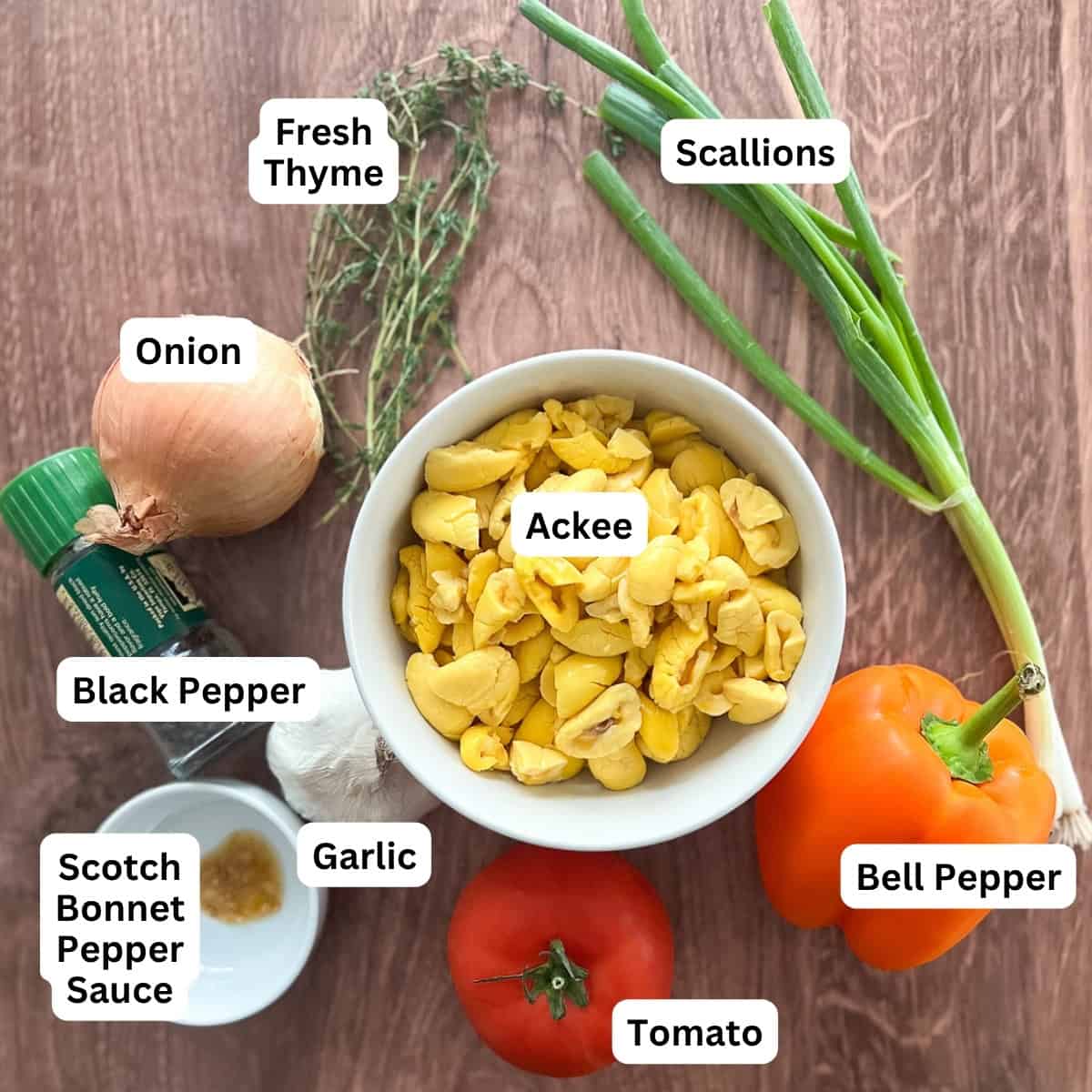 Vegan ackee ingredients: ackee, fresh thyme, scallion, onion, bell pepper, tomato, garlic, scotch bonnet pepper sauce, and black pepper.