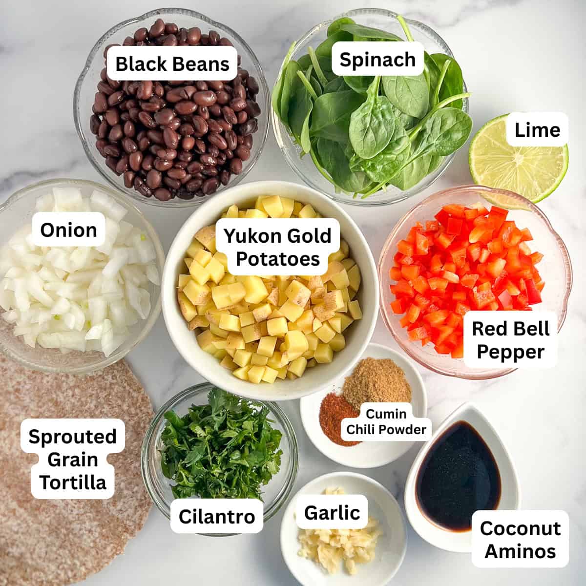 Ingredients used to make vegan breakfast burrito: black beans, spinach, red bell pepper, potatoes, onion, sprouted grain tortillas, cilantro, garlic, coconut aminos, lime and spices.