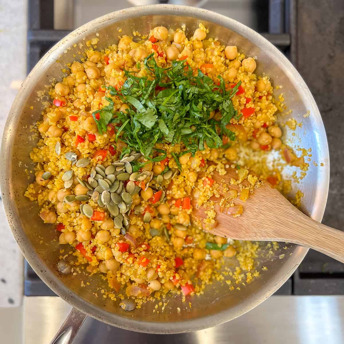 Finely chopped cilantro and pumpkin seeds added to the skillet with curry quinoa chickpea mixture.