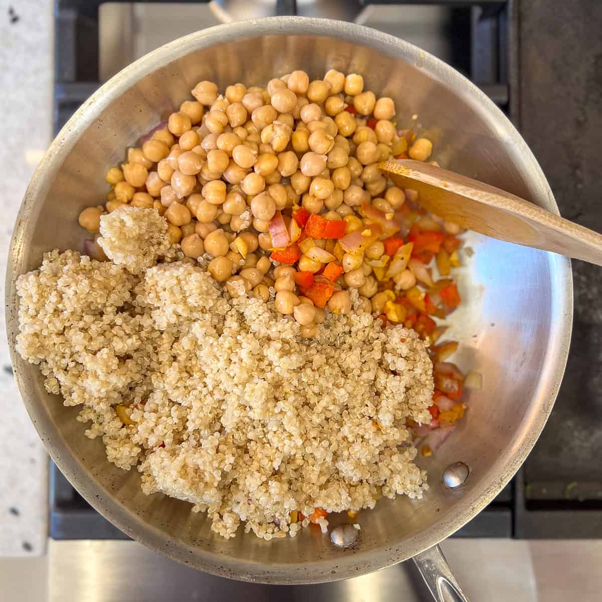 Chickpeas and quinoa added to the skillet with cooked veggies.
