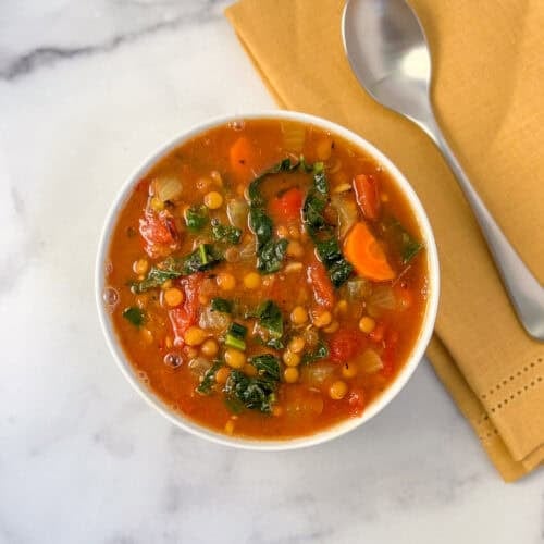 Bowl of lentil soup with spoon on the side.