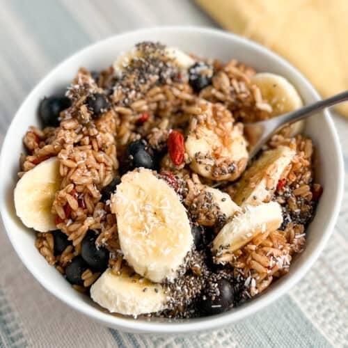 top side view close up of a white bowl with oat groats, fresh fruit and chia seeds