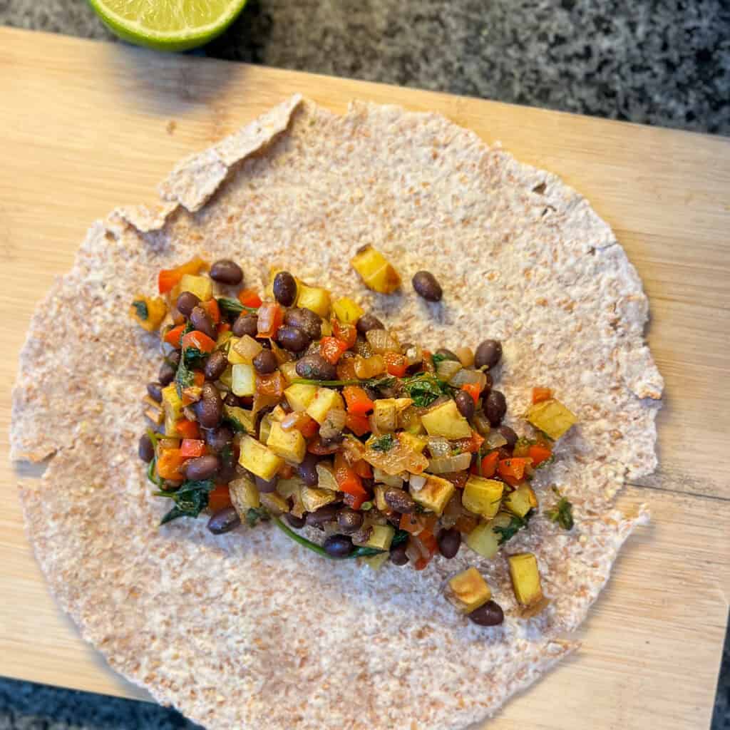 The cooked bean and potato mixture that's been added to a sprouted grain tortilla.