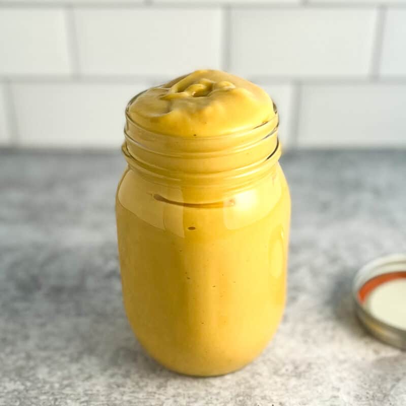 side view of vegan cheese sauce in a mason jar