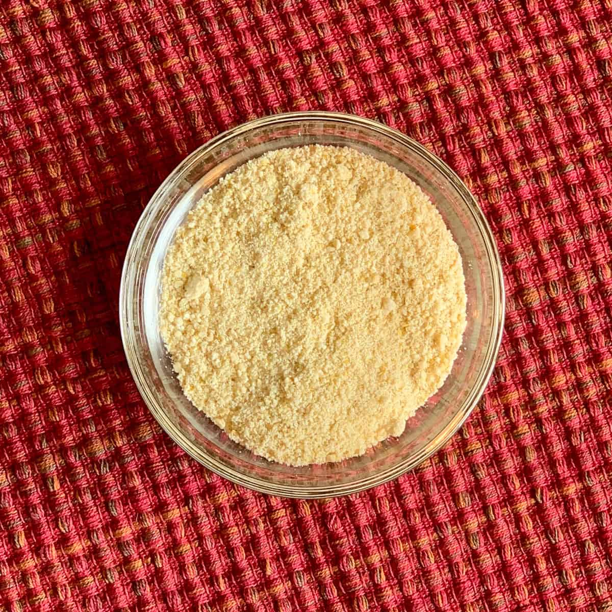 Vegan parmesan cheese in a glass dish.