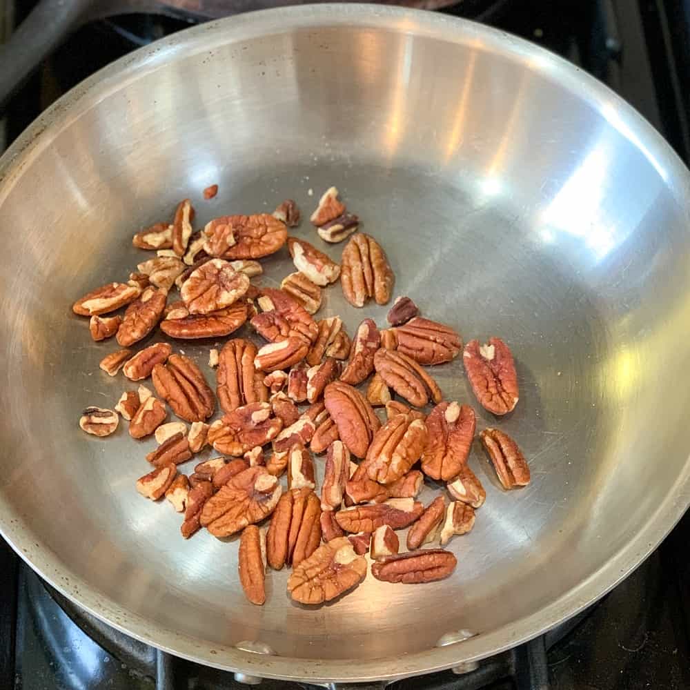 pecans toasting in a hot dry skillet to be added for the best toasted pecan balsamic vinaigrette