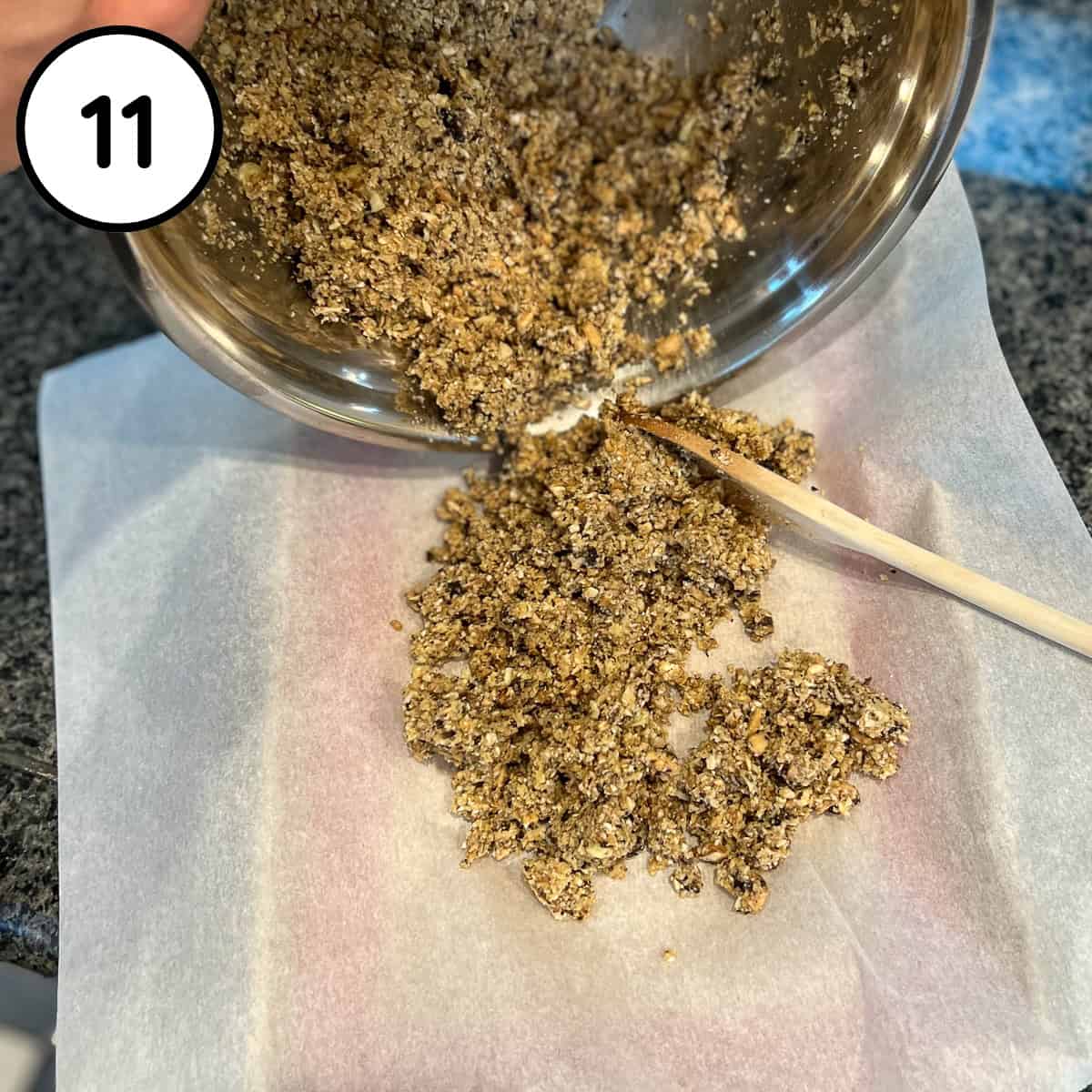 The walnut meat mixture being added to a parchment lined baking sheet.