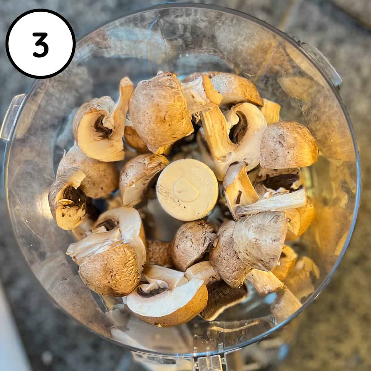 Mushrooms in a food processor bowl before processing.
