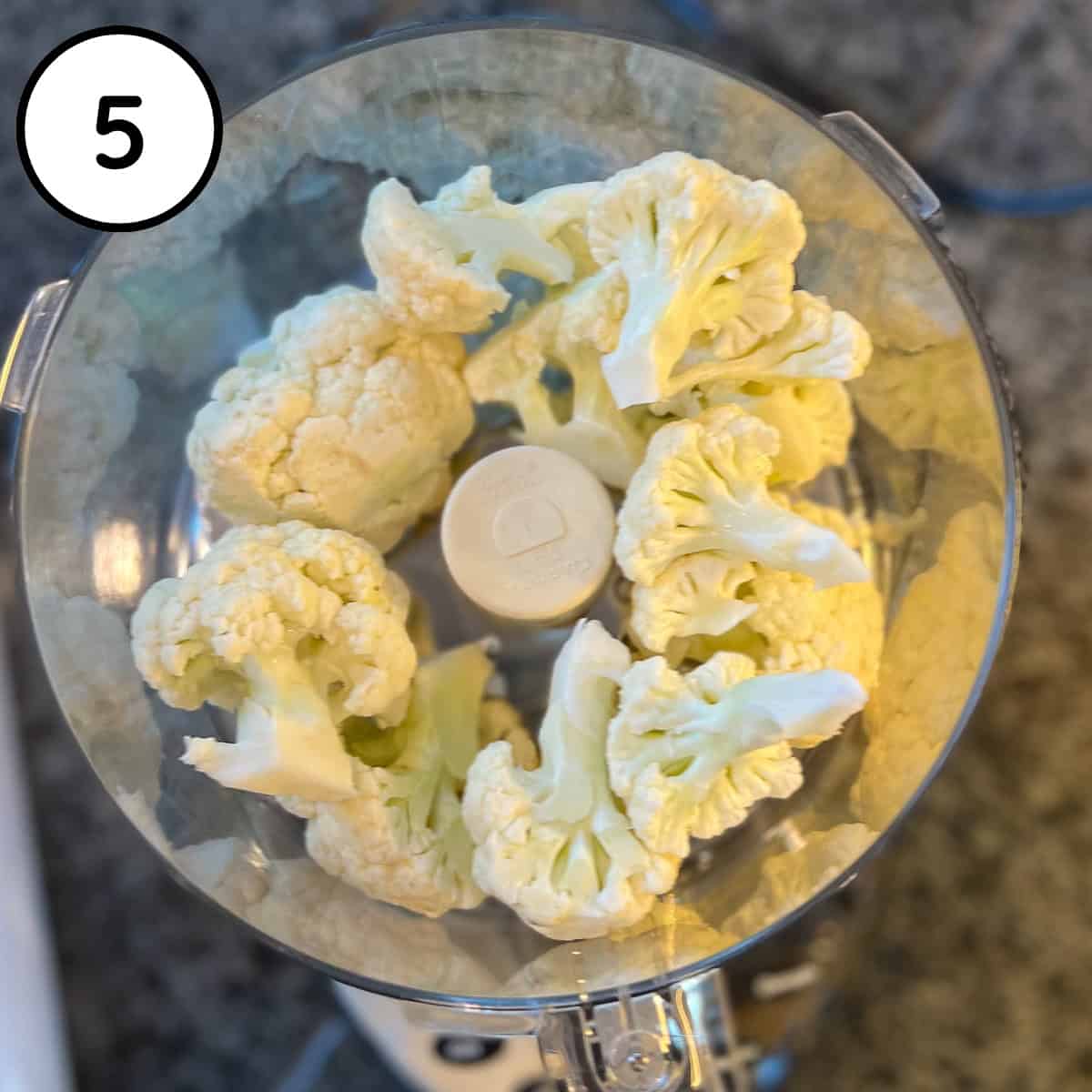 Cauliflower in a food processor bowl before processing.