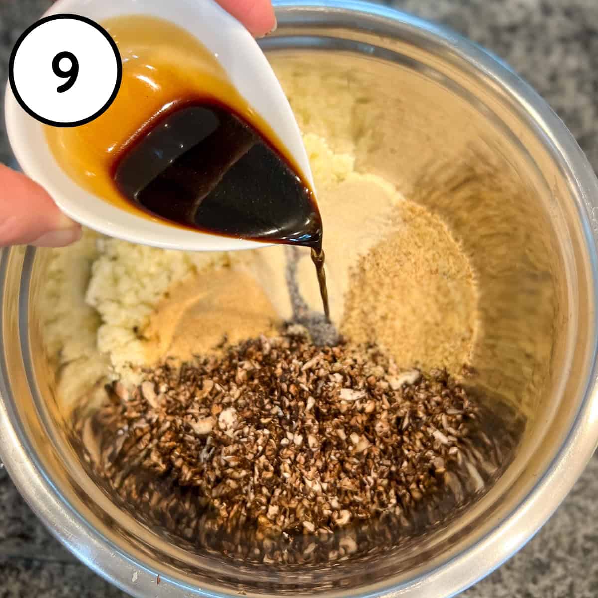 Coconut aminos being added to the mixing bowl with dried seasonings and other ingredients.