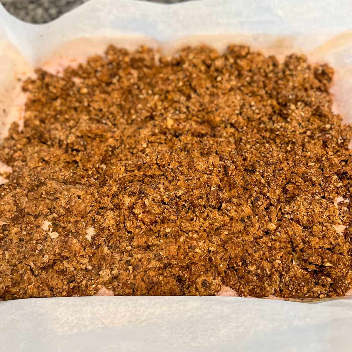 Cooked walnut meat on a parchment-lined baking sheet.