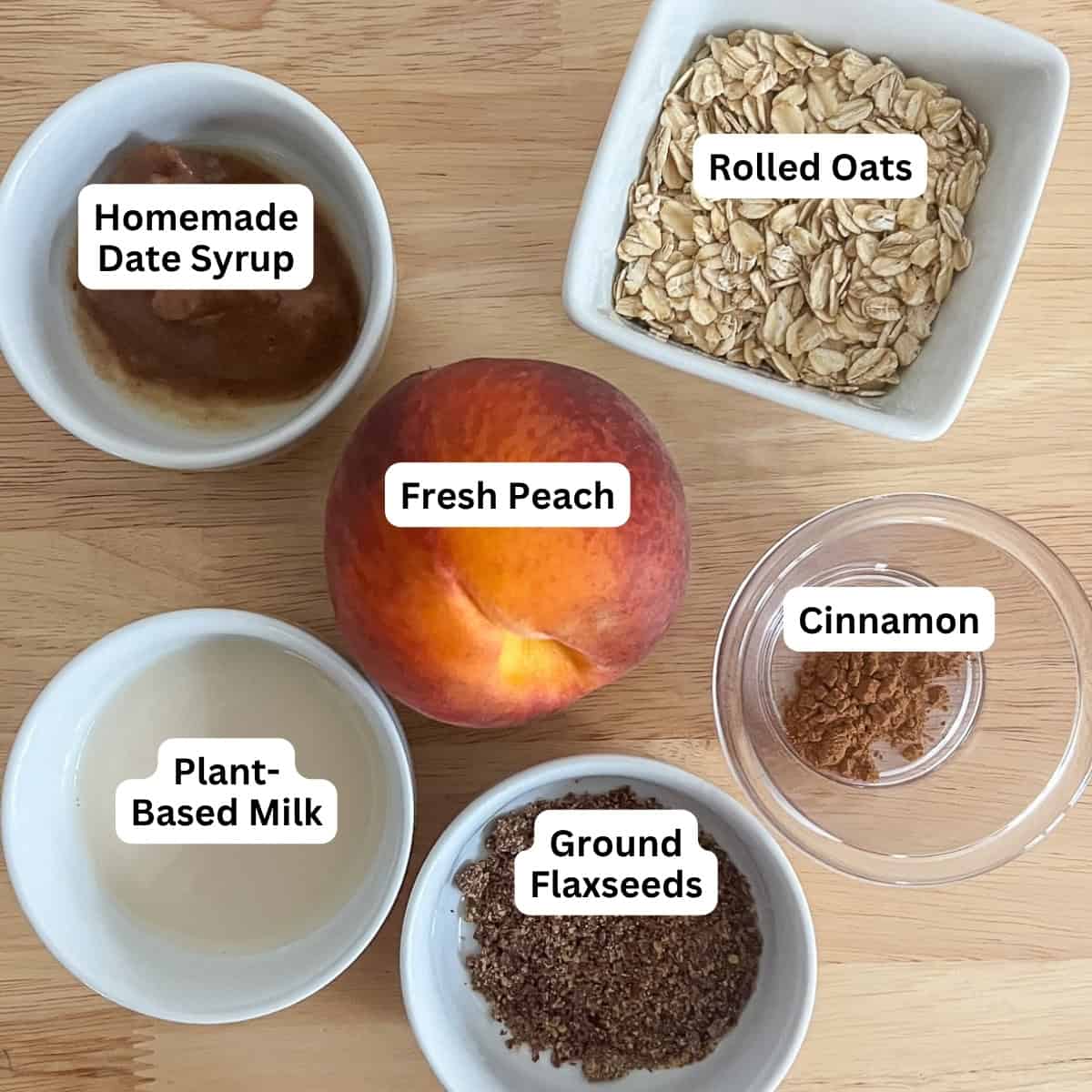 Ingredients for healthy peach cobbler: rolled oats, date syrup, fresh peach, cinnamon, ground flaxseeds, plant based milk.