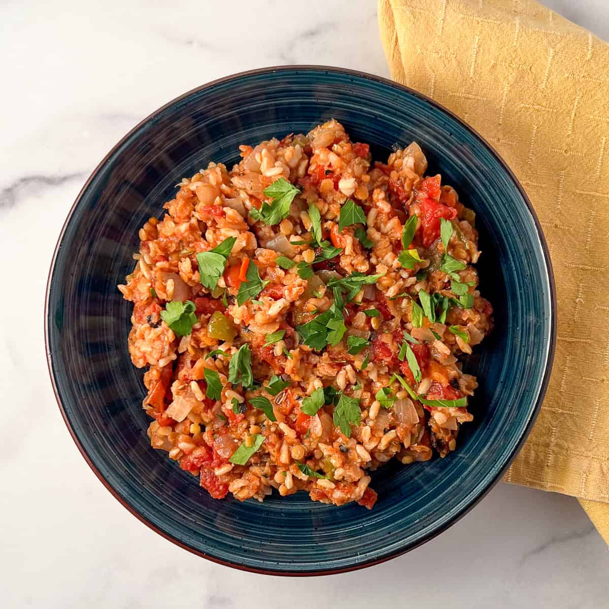 Deconstructed vegan stuffed peppers in a shallow bowl with napkin on the side.