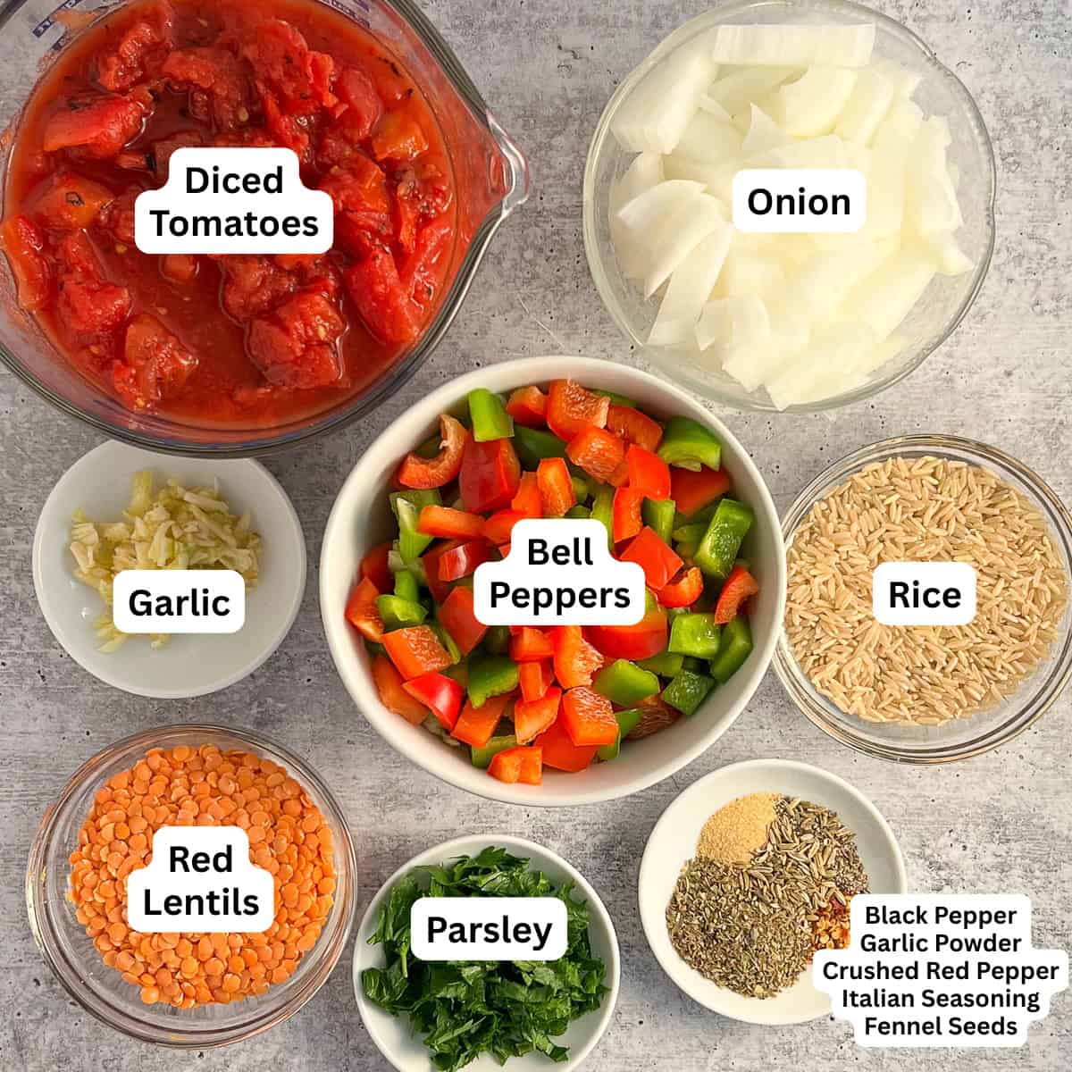 Deconstructed stuffed peppers ingredients: bell pepper, onion, rice, garlic, diced tomatoes, lentils, seasonings, and parsley.