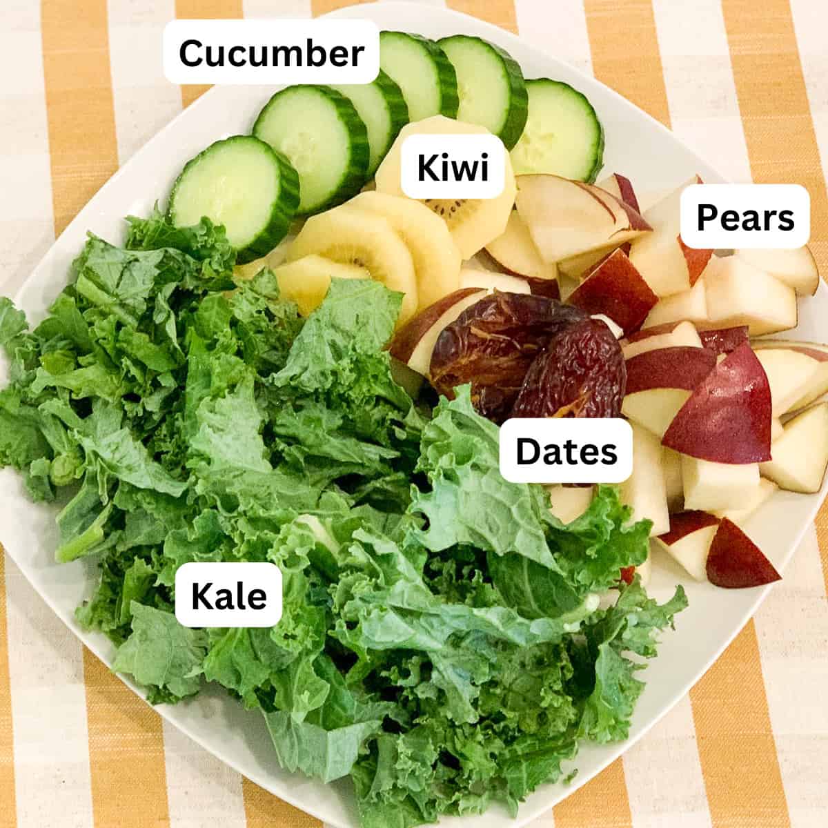 Ingredients for pear smoothie: pear, kale, cucumber, kiwi, and dates.