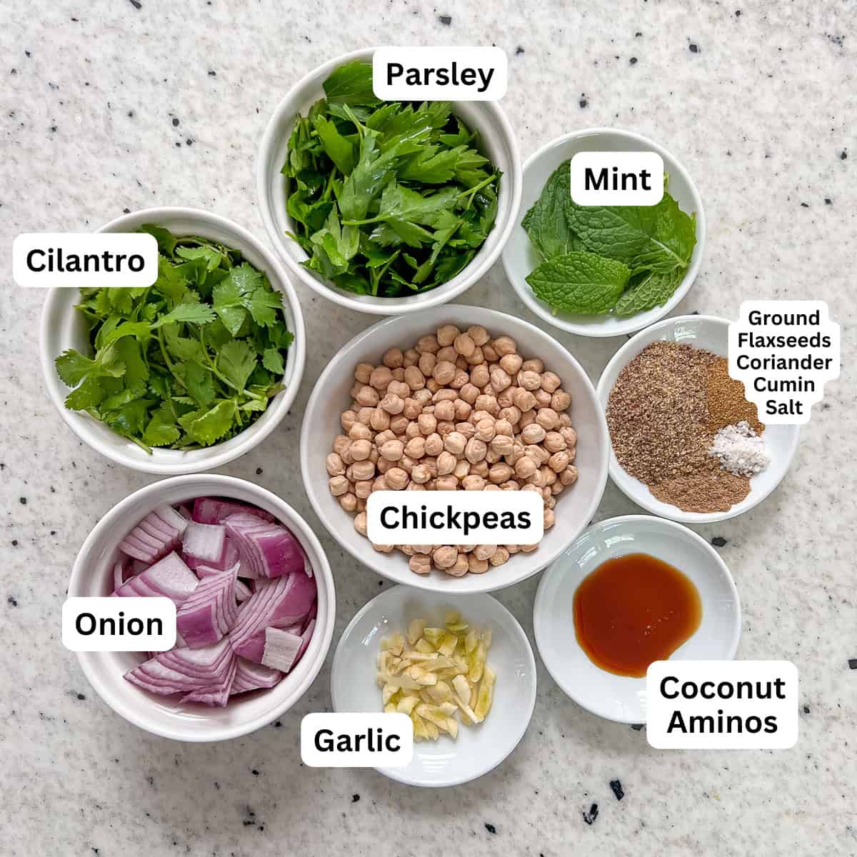 The ingredients for air fryer falafels: chickpeas, onion, garlic, herbs and spices.