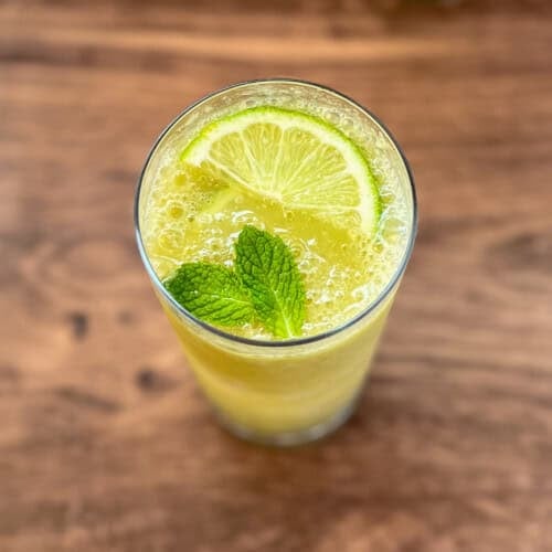 Frosty mojito mocktail with fresh mint leaves and sliced lime.