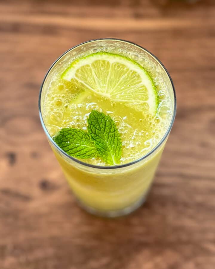 Frosty mojito mocktail with fresh mint leaves and sliced lime.