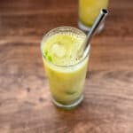Mojito mocktail in a tall glass with metal straw.