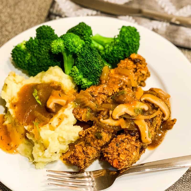 top view of lentil quinoa loaf alongside garlic mashed potatoes, mushroom gravy and steamed broccoli