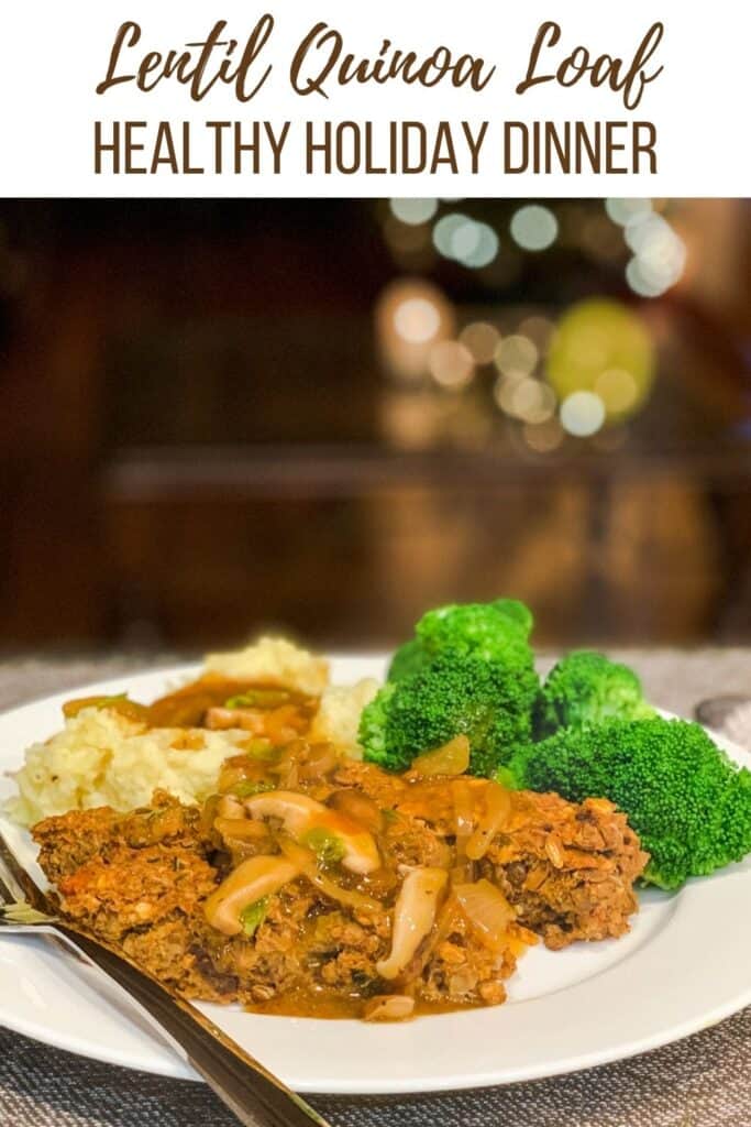 Side view close up of lentil quinoa loaf with garlic mashed potatoes, caramelized onion and mushroom gravy and a side of steamed broccoli on a white plate. a christmas tree blurred in the background.