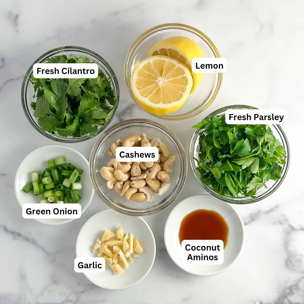 Ingredients for green goddess dressing: cilantro, parsley, lemon juice, cashews, green onion, garlic, coconut aminos.