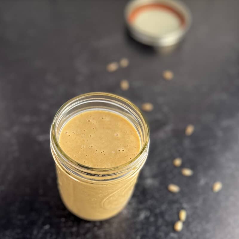 top side view close up of sweet and tangy sunflower butter sauce in a glass mason jar