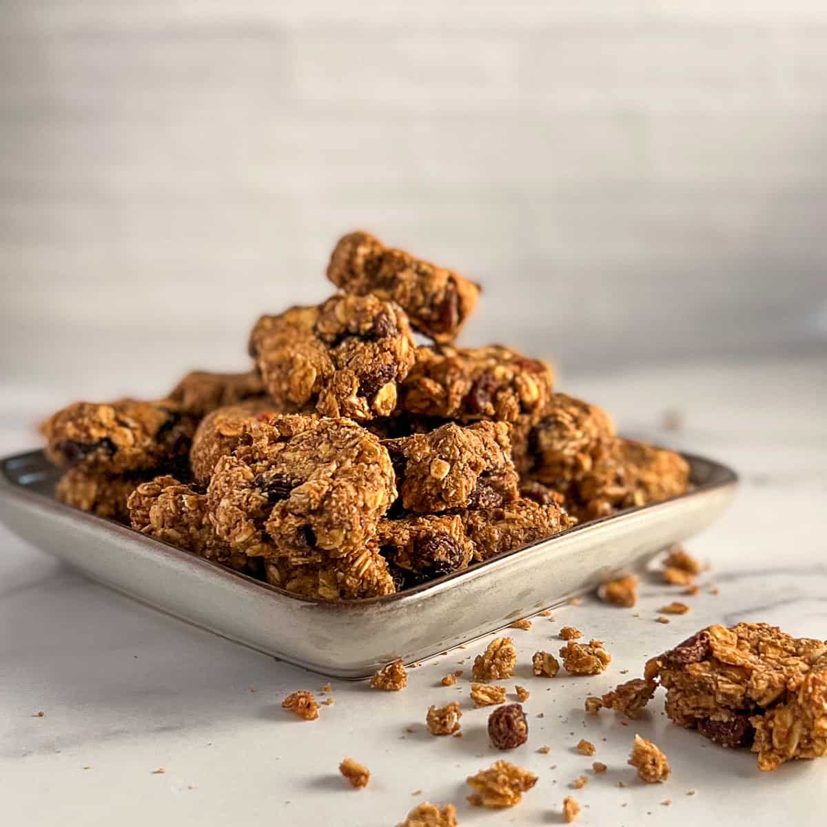 A pile of oatmeal raisin cookies on a plate.