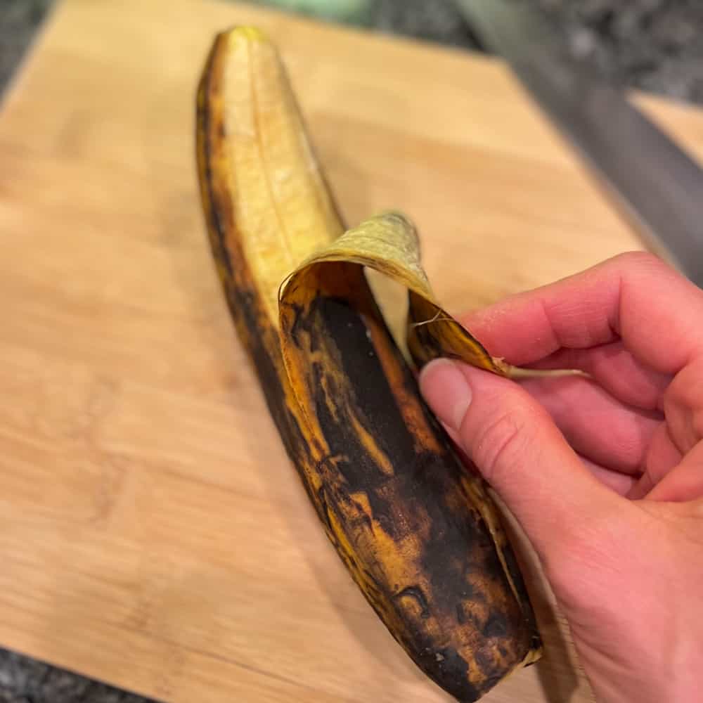 a ripe plantain being peeled