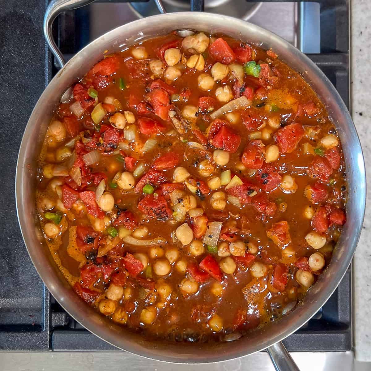 Vegan chana masala being brought to a gentle simmer.