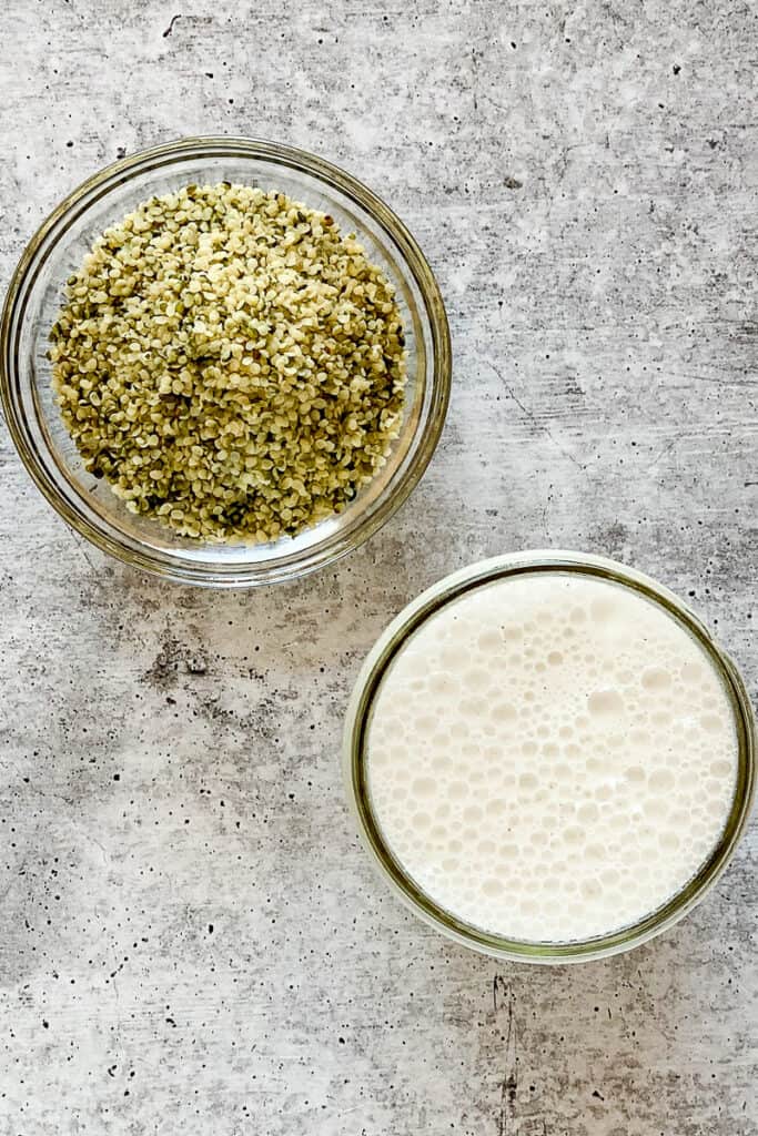 top view close up of hemp hearts and a jar of hemp milk on a concrete surface