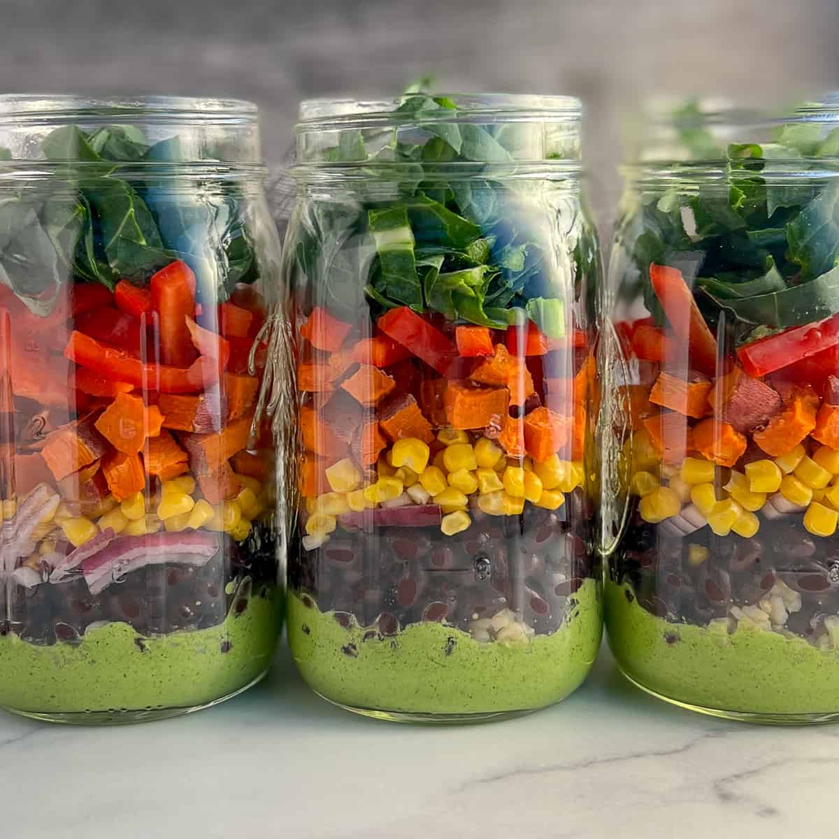 side view of three mason jars with Southwestern Salad