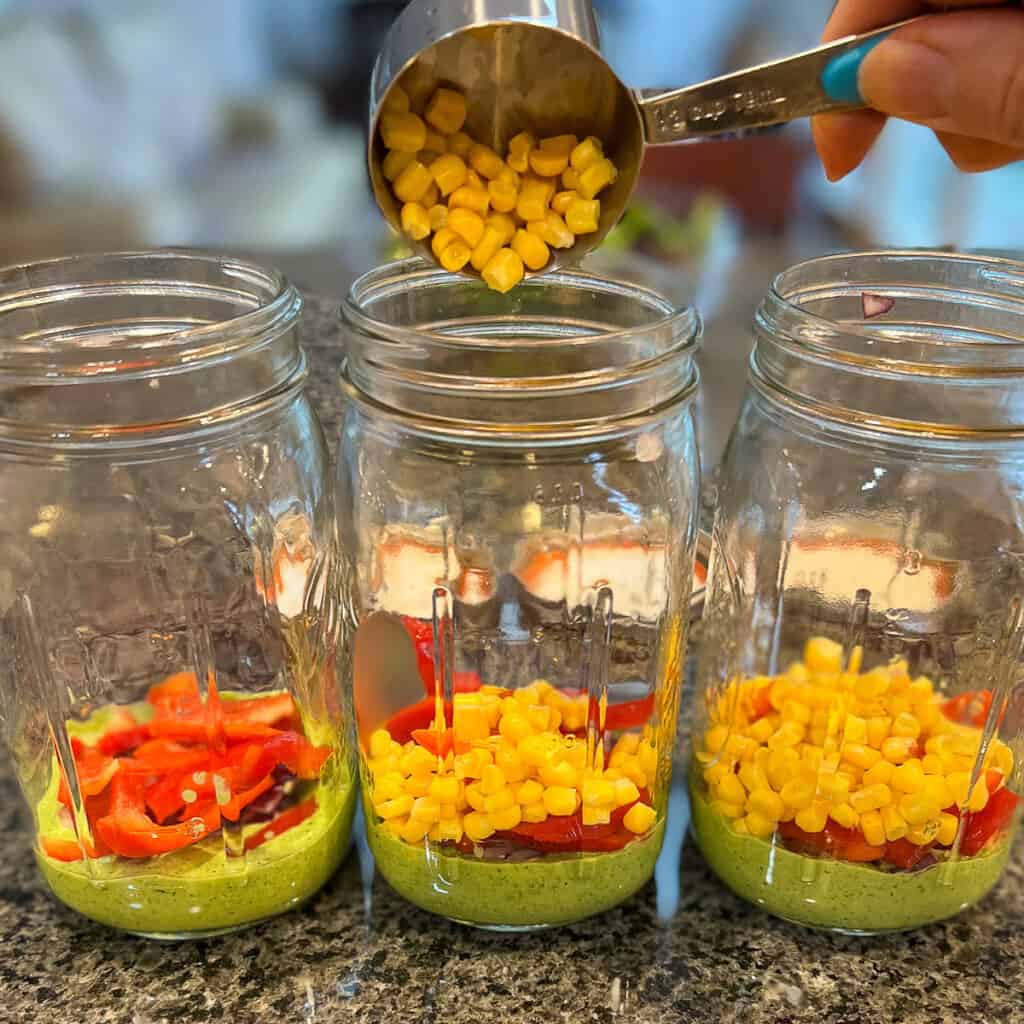 corn being added to the mason jars