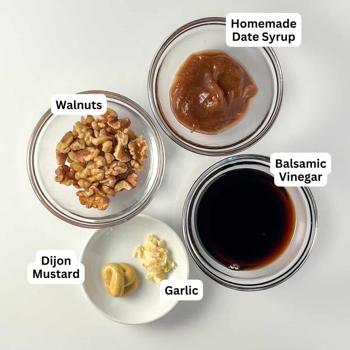 Ingredients for the walnut salad dressing: walnuts, date syrup, balsamic vinegar, Dijon mustard and garlic.