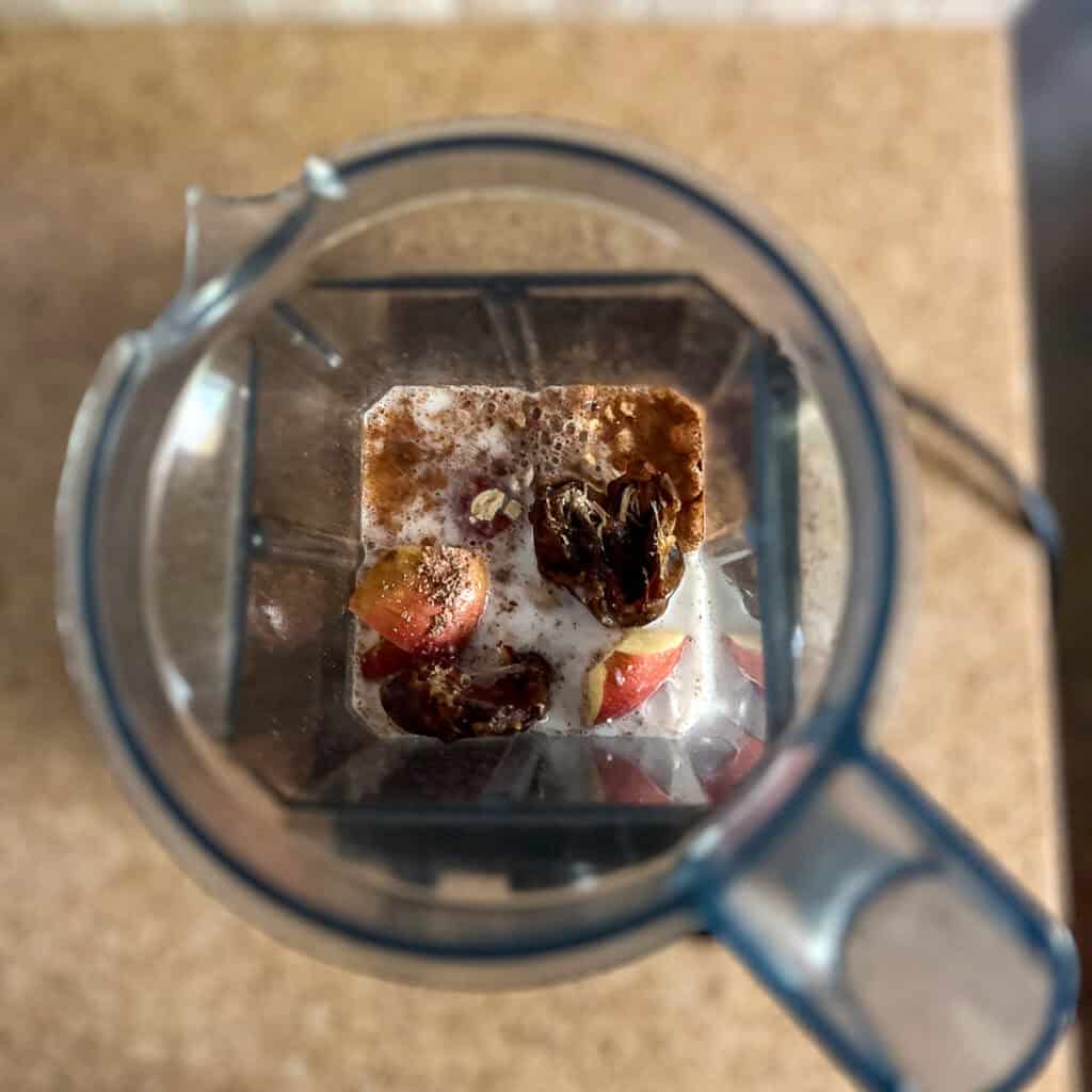 Ingredients for apple smoothie in a blender pitcher.
