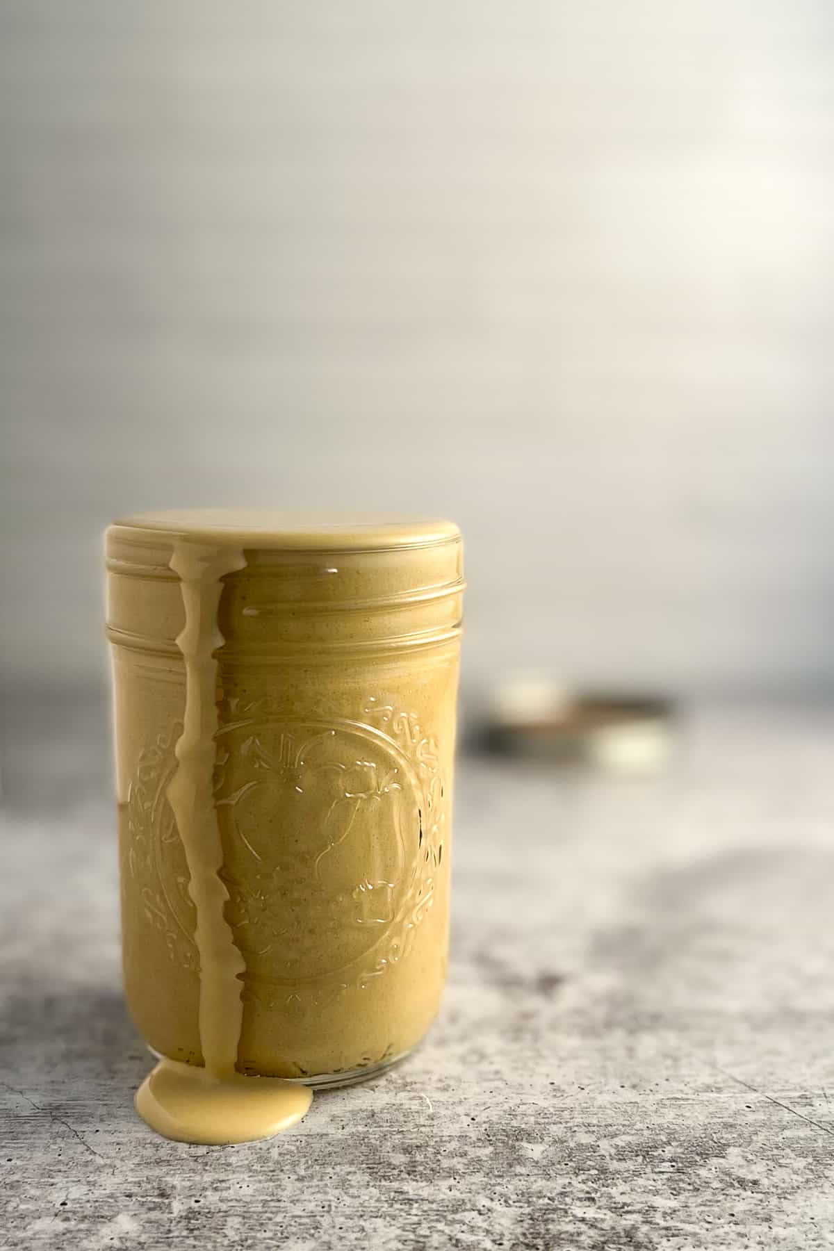 side view of tahini pasta sauce in a mason jar