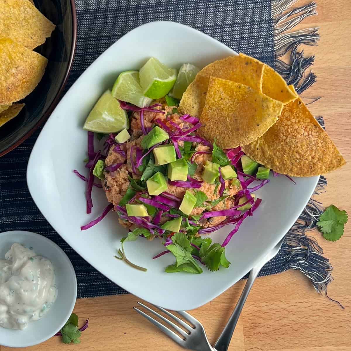 top view close up of vegan tuna salad with oven baked chips, diced avocado, lime and chopped purple cabbage