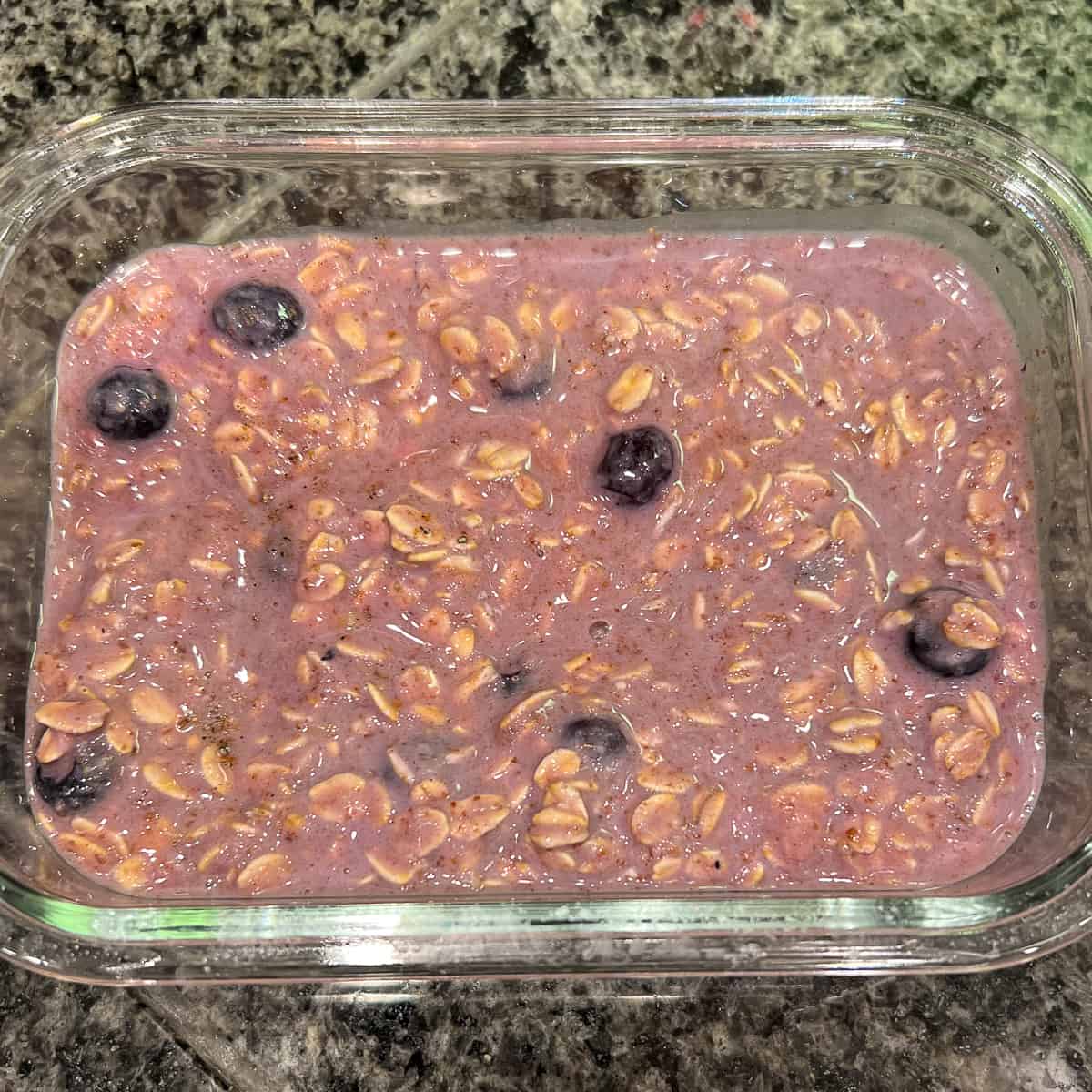 top view close up of lemon blueberry baked oatmeal batter in a glass meal prep container