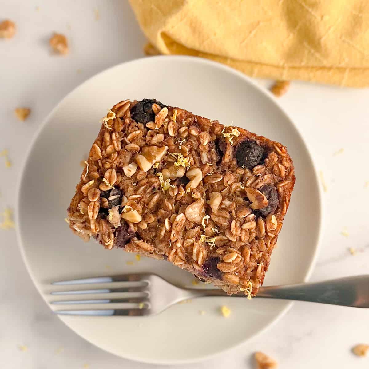 top view close up of a slice of lemon blueberry baked oatmeal on a white plate