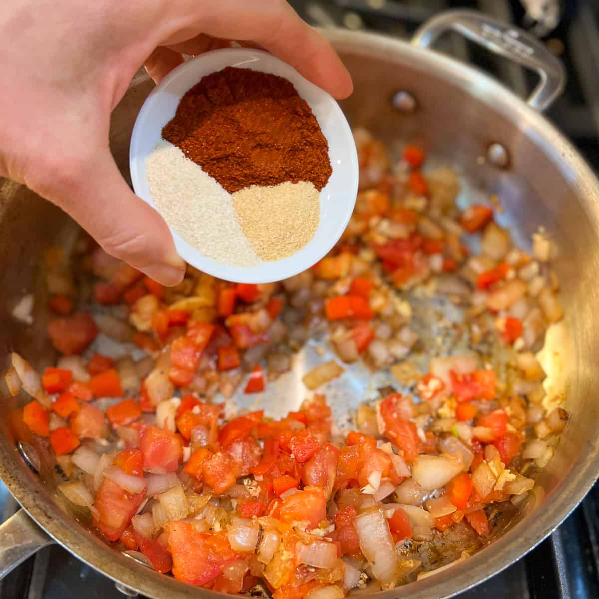 Dried spices being added to the pan.