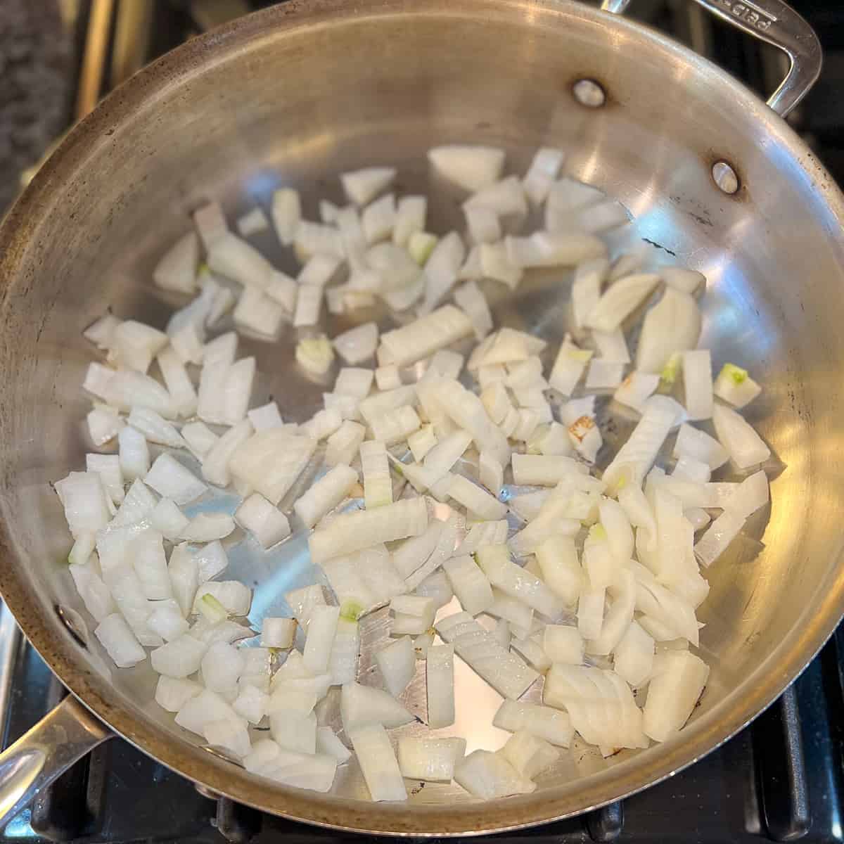Chopped onions sautéing in a pan.