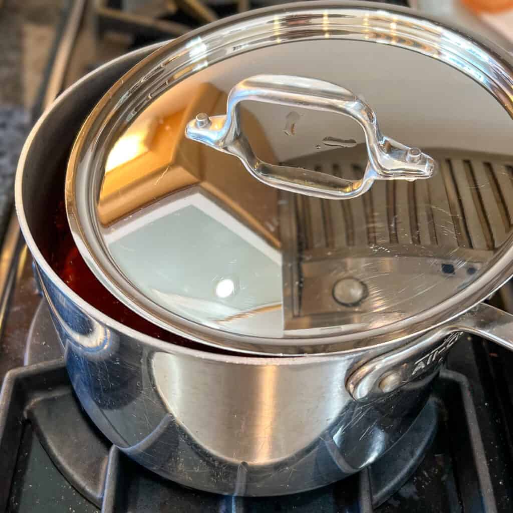 side top view of partially covered pot on a stovetop